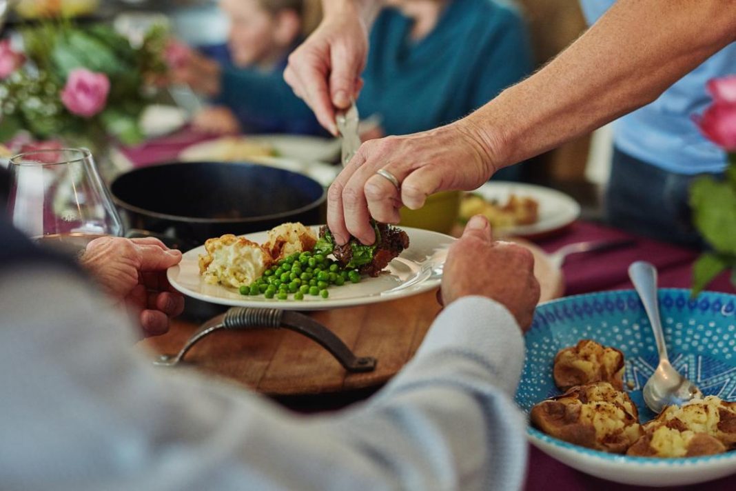 close-up-of-plate-of-food-being-passed-around-at-dinner-table