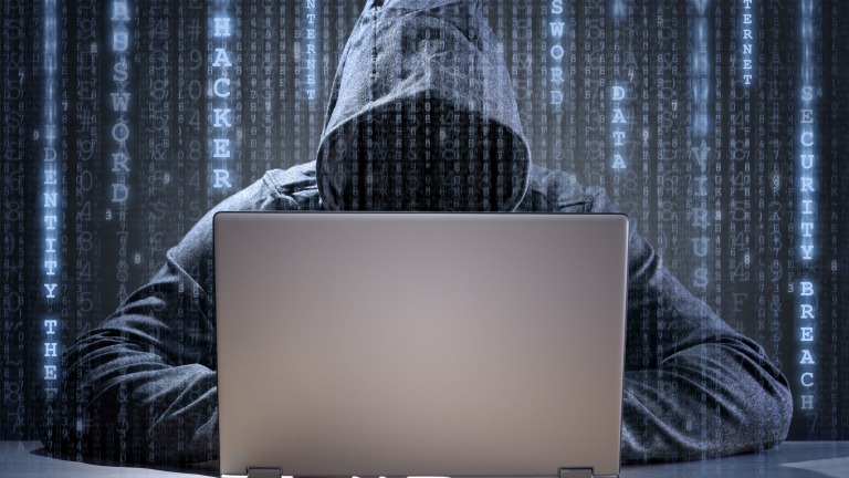 Computer hacker stealing data from a laptop