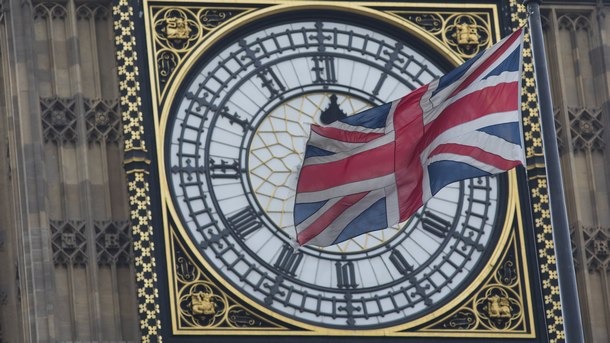 The Union Flag flutters near a view of the Houses of Parliament in London
